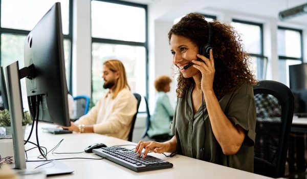 Werkende vrouw in een call center met headset en computer