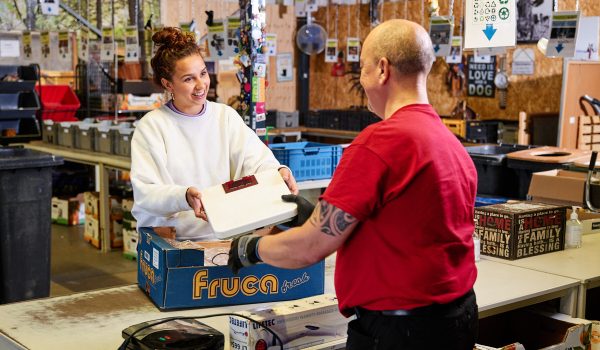Iemand die een apparaat inlevert bij de kringloopwinkel.